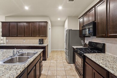 Kitchen features include granite countertops paired with a coordinating stone backsplash, high-end appliances, rich cabinets, recessed lighting, and a sprawling island with breakfast bar seating.