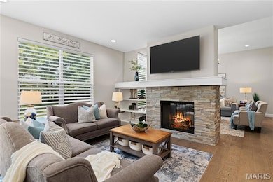 Living area featuring wood finished floors, a fireplace, and recessed lighting