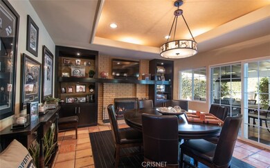 Game room with gas fireplace, built-ins, inlay wood floor & opens to expansive covered patio