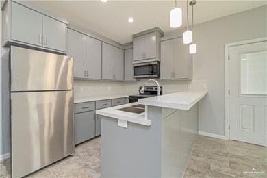Kitchen with backsplash, gray cabinets, stainless steel appliances, and decorative light fixtures