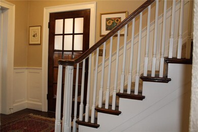 Staircase to upper level and front door entrance.