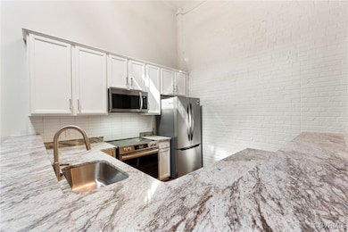 Kitchen featuring decorative backsplash, appliance