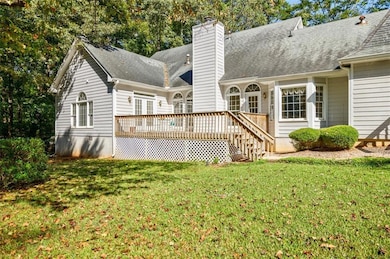 Back of house with a wooden deck, a chimney, roof 