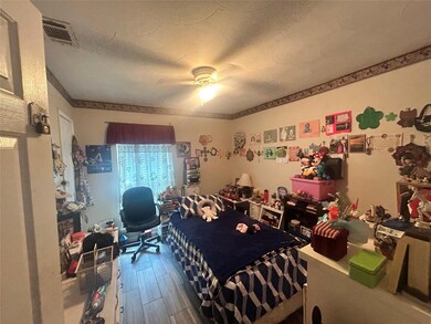Bedroom featuring a textured ceiling, hardwood / w