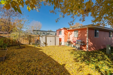 Back of house with a storage shed and a fenced backyard