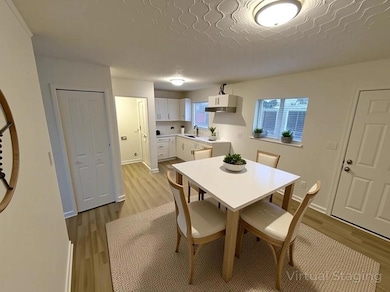 Dining space with light wood-type flooring and a textured ceiling