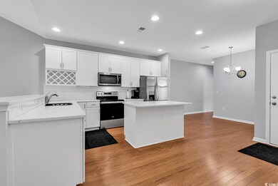 Kitchen with hanging light fixtures, a notable cha