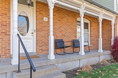 Property entrance featuring brick siding and covered porch