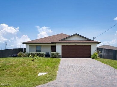 Ranch-style house with stucco siding, an attached garage, and decorative driveway