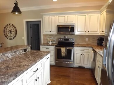 Kitchen has stainless steel appliances and a beautiful tile back-splash!