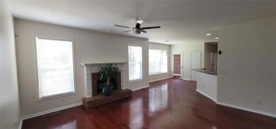 Unfurnished living room featuring a ceiling fan, wood finished floors, a fireplace with raised hearth, and recessed lighting
