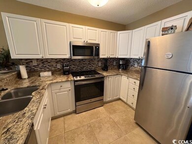 Kitchen featuring stainless steel appliances, back