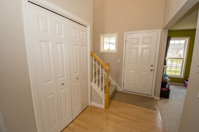 Welcoming foyer with coat closet and open staircas