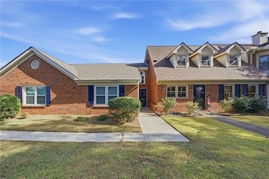 View of front of home featuring a front yard, brick siding, and roof with shingles