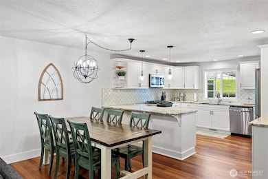 Kitchen with dining space where refinished hardwood flooring makes the main level flow from space to space.
