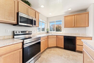 Kitchen with stainless steel appliances, light brown cabinetry, light countertops, and recessed lighting
