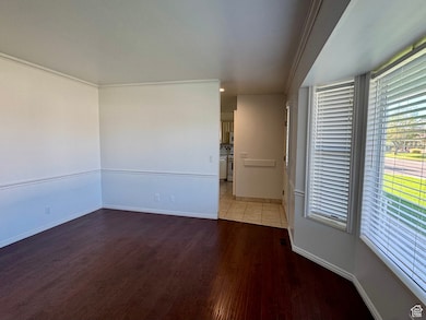 Spare room featuring wood finished floors, crown molding, and recessed lighting