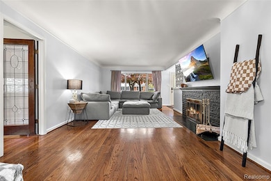 Living area with a glass covered fireplace and dark wood-style flooring