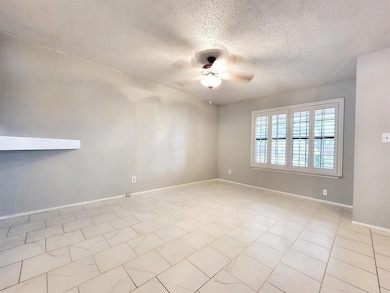 Unfurnished room featuring a textured ceiling and a ceiling fan