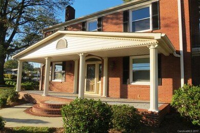 ROUNDED BRICK STEPS LEAD TO LARGE COVERED FRONT PO