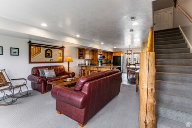 Living room with carpet, a textured ceiling, stairway, and recessed lighting