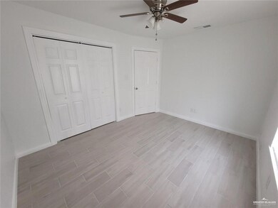Unfurnished bedroom with wood finished floors, a closet, baseboards, and a ceiling fan
