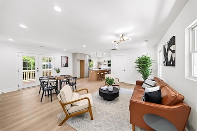 Living area featuring recessed lighting, light wood-type flooring, french doors, and a chandelier