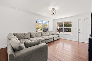 Living area featuring ornamental molding and wood finished floors