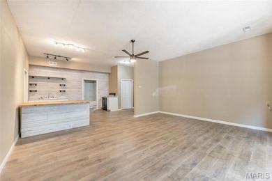 Unfurnished living room with a ceiling fan and light wood-style flooring