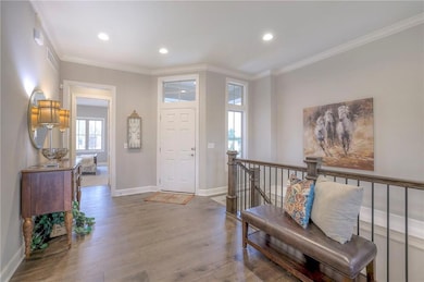 Entryway featuring hardwood / wood-style flooring and crown molding