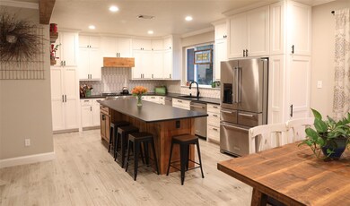 Kitchen with sink, a kitchen island, light hardwoo