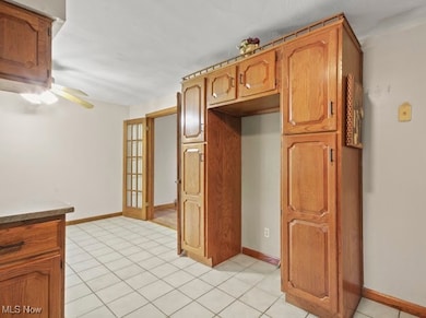 Kitchen featuring light tile patterned floors and brown cabinets