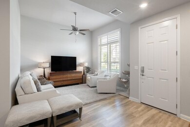 Living area featuring ceiling fan, light wood-sty