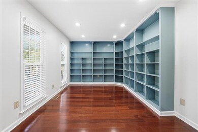 Spare room featuring dark wood-style floors, recessed lighting, and built in features