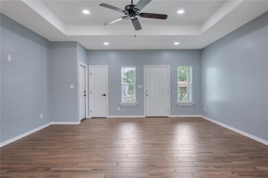 Entryway featuring a raised ceiling, dark wood fin