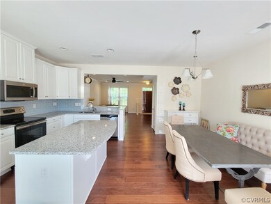 Kitchen with hardwood flooring, island, stainless