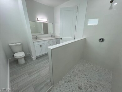Full bathroom featuring double vanity, toilet, and