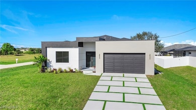 Contemporary house with fence, a garage, a front y