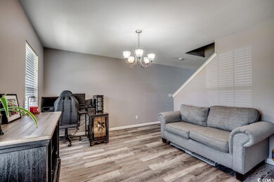 Home office with light wood-style floors and a chandelier