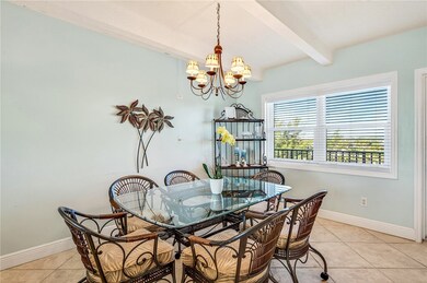Dining space with beam ceiling, light tile floors, and a chandelier