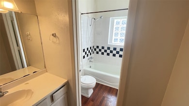 Vintage tiles and glass block window in the bathroom with separate vanity and sink.