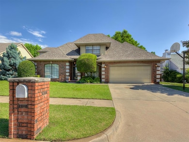 View of front of house with roof with shingles, brick siding, an attached garage, driveway, and a front lawn