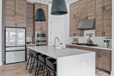 Kitchen with exhaust hood, a sink, tasteful backs