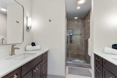 Full bathroom featuring vanity, a stall shower, recessed lighting, and light tile patterned floors