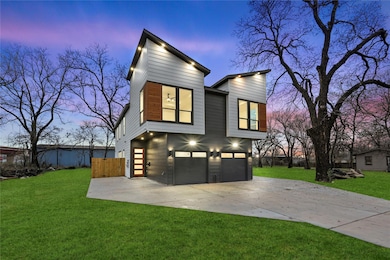 Back house at dusk featuring a lawn and a garage
