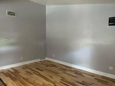 Empty room featuring wood finished floors and bas
