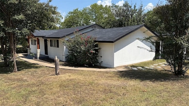 View of home's exterior with a lawn and roof with shingles