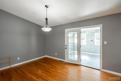 Unfurnished dining area featuring light wood-style floors and baseboards