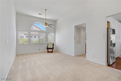 Carpeted spare room featuring ceiling fan and base