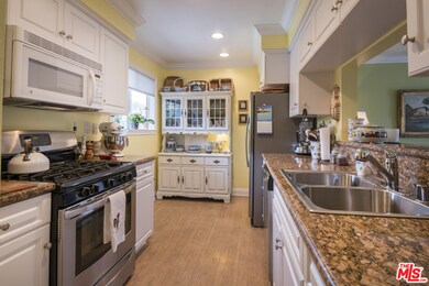 Kitchen overlooks pool and tree top views.  Room f